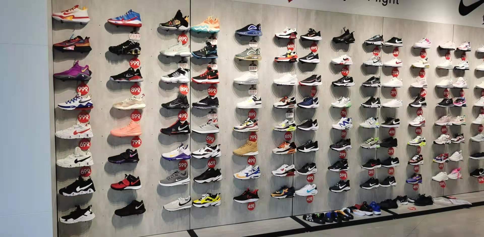 Wall-mounted shoe trays arranged across a finished display wall