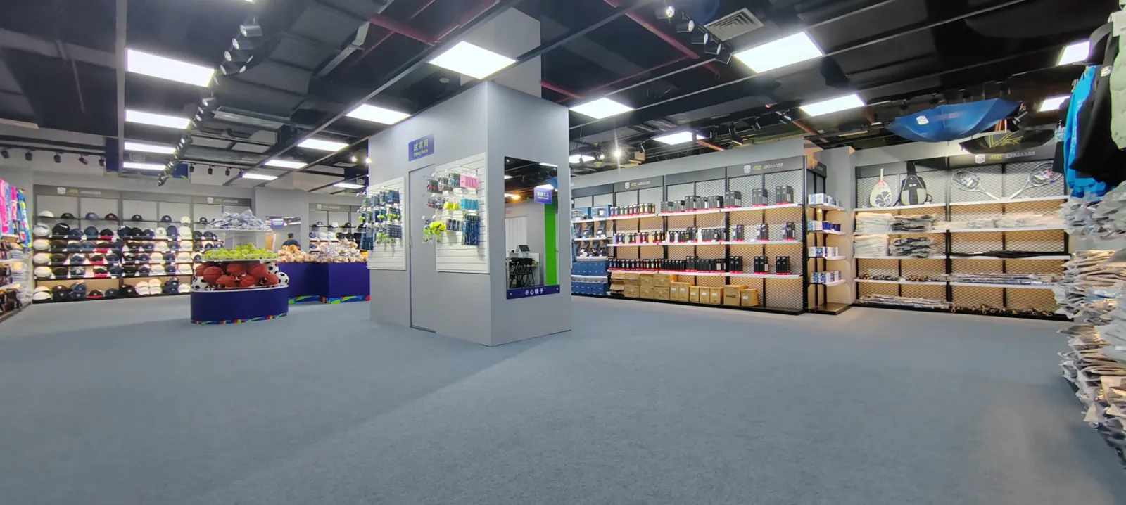 Mesh wall bays, slatwall panels and a fitting room in a sports merchandise store.