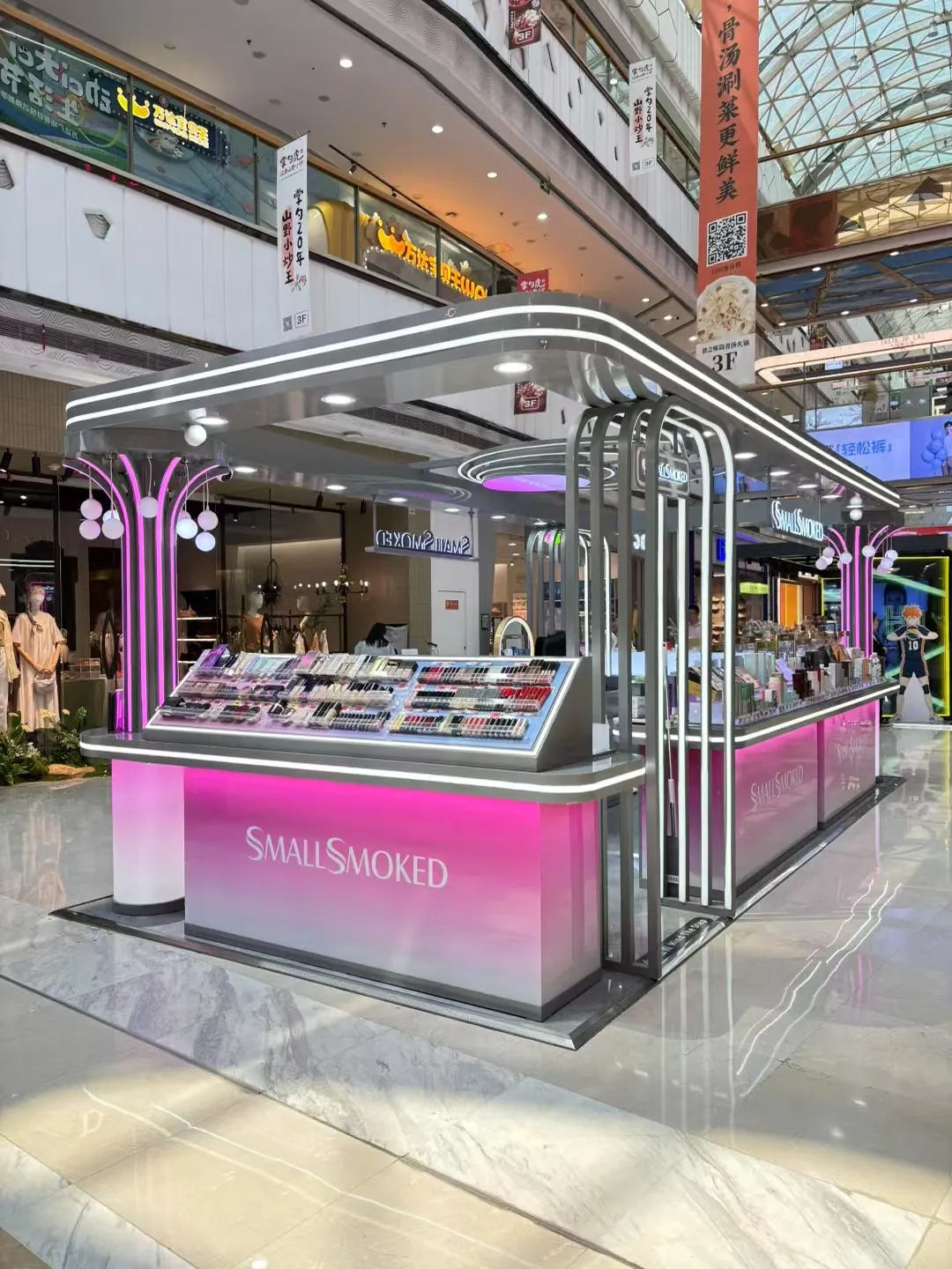 A mall kiosk with a white metal canopy and glass counters